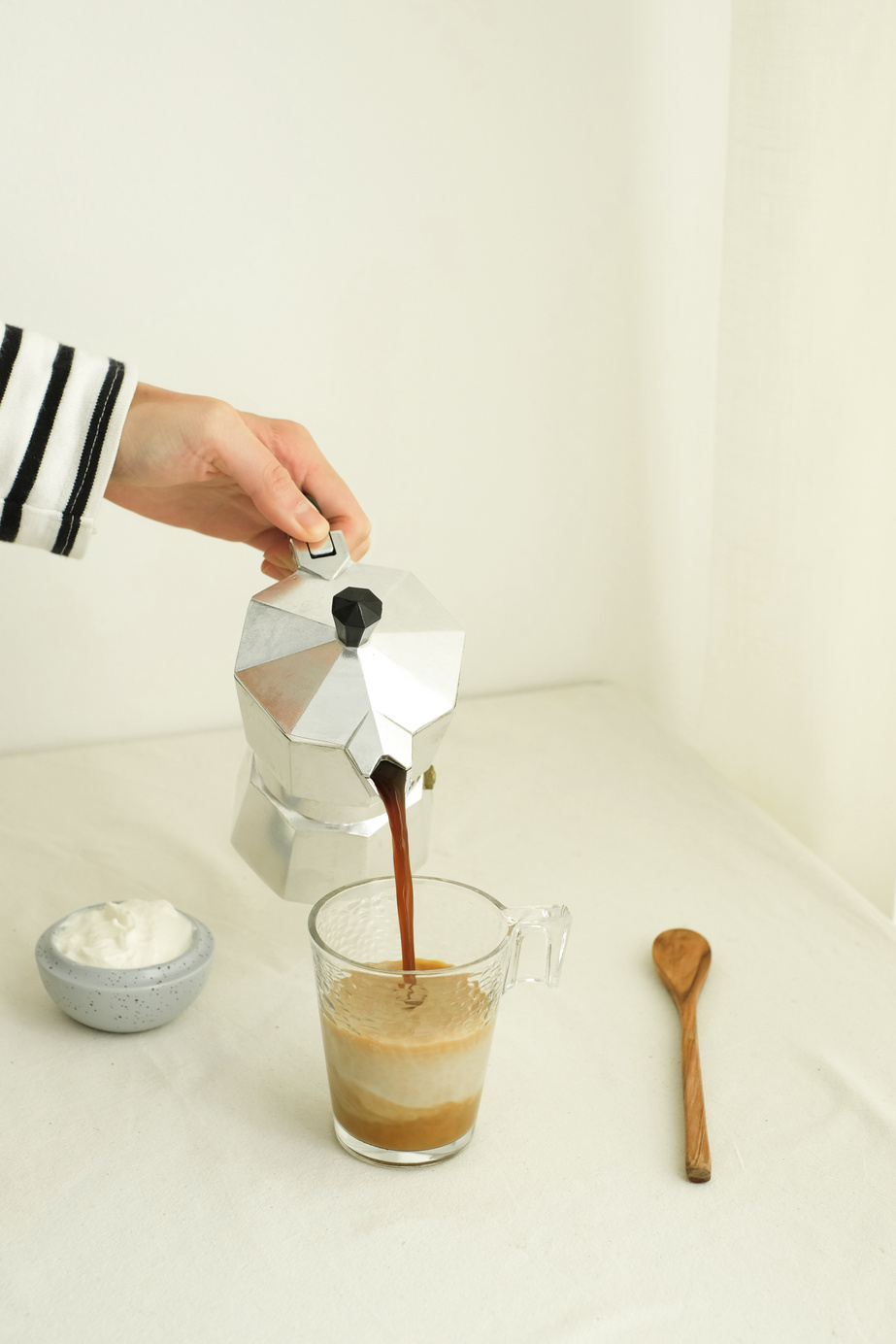 Hand Pouring Coffee into Glass Mug